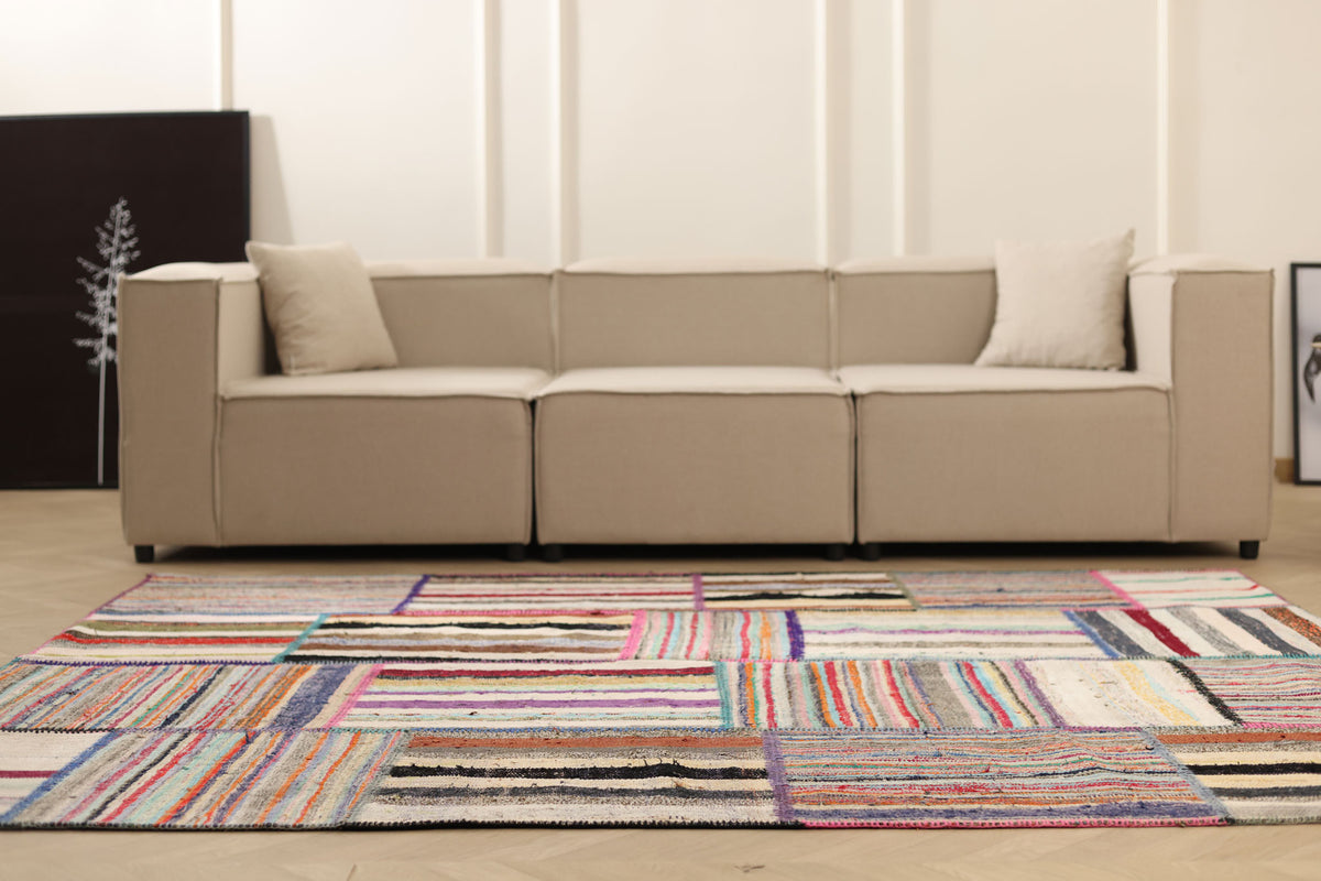 Handmade 6x8 ft vintage Turkish patchwork area rug featuring vibrant multi-colored striped patterns in wool and cotton.