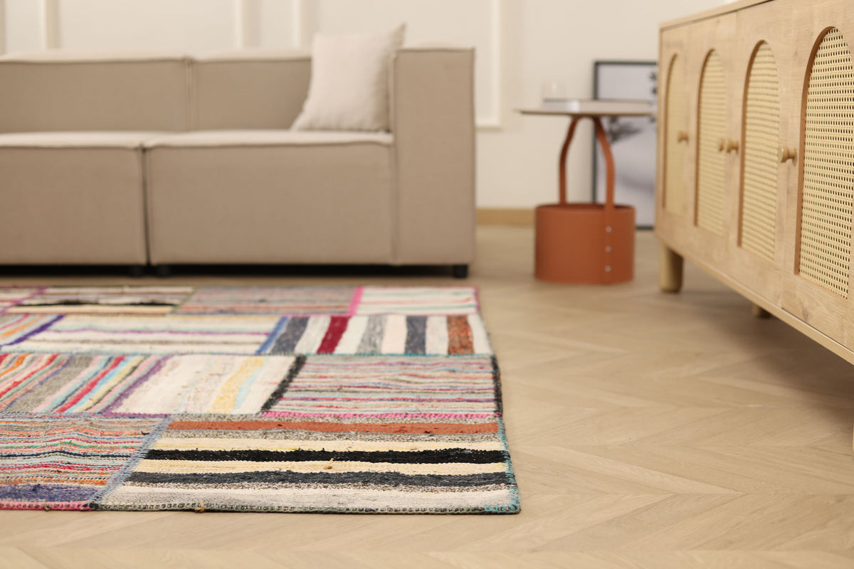 Handmade 6x8 ft patchwork Turkish area rug featuring vibrant, multi-colored striped patterns in a wool and cotton flatweave.