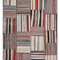 Handmade 6x8 ft vintage Turkish patchwork area rug featuring a colorful mix of striped wool and cotton flatweave patterns.