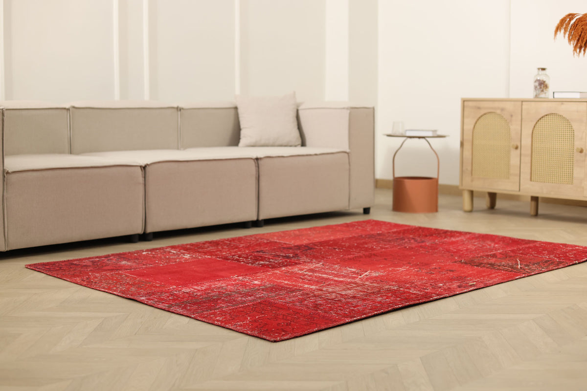 5x7 ft vintage red patchwork area rug made of wool and cotton with overdyed bohemian patterns in a modern living room.