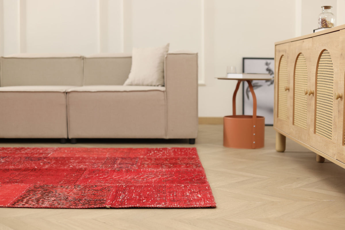 5x7 ft red patchwork Turkish area rug made of wool and cotton with a vintage overdyed design in a bohemian living room.