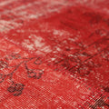 Close-up of a red vintage Turkish patchwork area rug featuring hand-stitched wool and cotton with faded bohemian patterns.