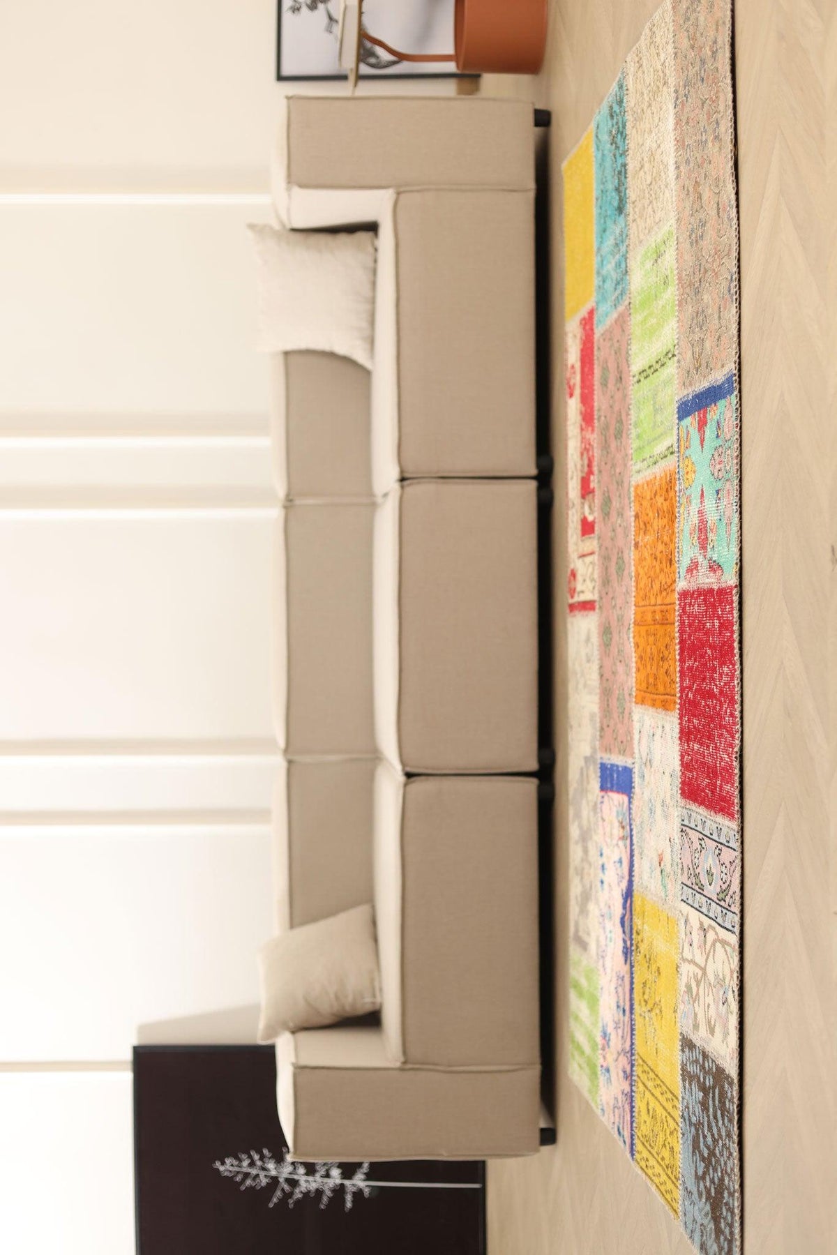 5x7 ft handmade patchwork Turkish area rug with vibrant geometric patterns in wool and cotton, styled in a modern living room.