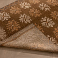 Handwoven brown and beige Turkish runner rug with geometric patterns and a folded corner showing the wool and cotton weave.