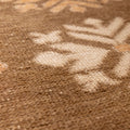 Close-up of a vintage Turkish wool and cotton runner rug featuring brown and beige geometric tribal patterns.