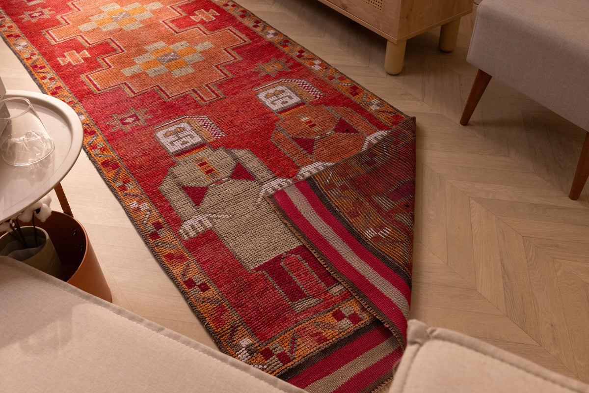 Handmade 3.3x11.5 ft wool and cotton Persian runner rug in red and orange with traditional human-figured patterns.