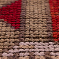 Close-up of a handmade Persian runner rug in red and orange wool-cotton blend with traditional figured patterns.