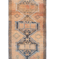 Vintage 4x11 ft Turkish runner rug in orange and brown wool with geometric tribal patterns and a distressed low-pile finish.