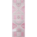 Hand-woven 2x11 ft vintage Turkish runner rug in faded pink and gray with geometric patterns and wool-cotton blend.