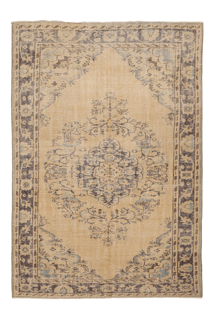 A traditional oriental-style area rug with a distressed medallion pattern, featuring a warm beige center and border with muted gray and brown details.