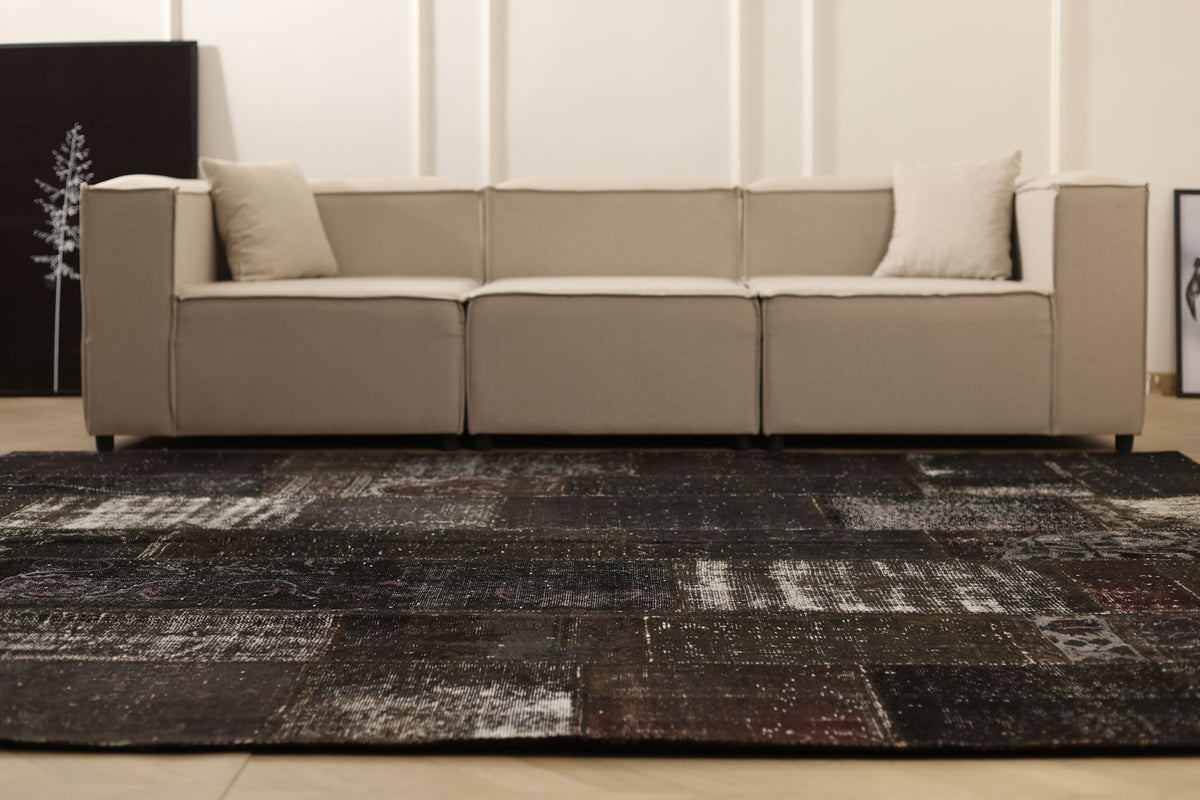 8x9 ft black patchwork Turkish area rug featuring distressed, hand-stitched wool and cotton patterns in a bohemian style.