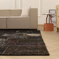 8x9 ft black patchwork vintage Turkish area rug with distressed patterns in a bohemian living room setting.
