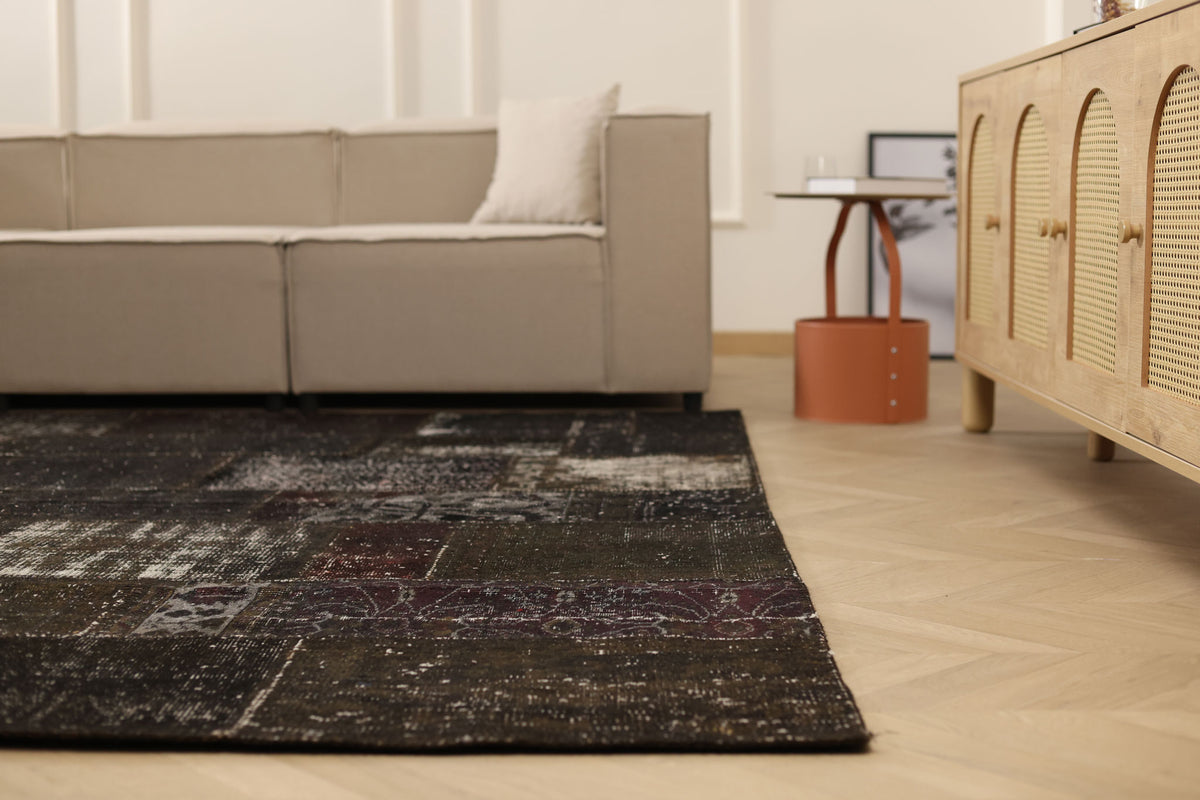 8x9 ft black patchwork vintage Turkish area rug with distressed patterns in a bohemian living room setting.