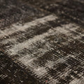 Hand-stitched black patchwork Turkish area rug with a distressed, low-pile wool and cotton texture.