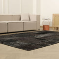 6x9 ft black patchwork Turkish area rug with distressed wool and cotton patterns in a modern bohemian living room.