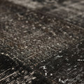 Handmade black patchwork Turkish rug with a distressed, low-pile wool and cotton texture and vintage bohemian patterns.