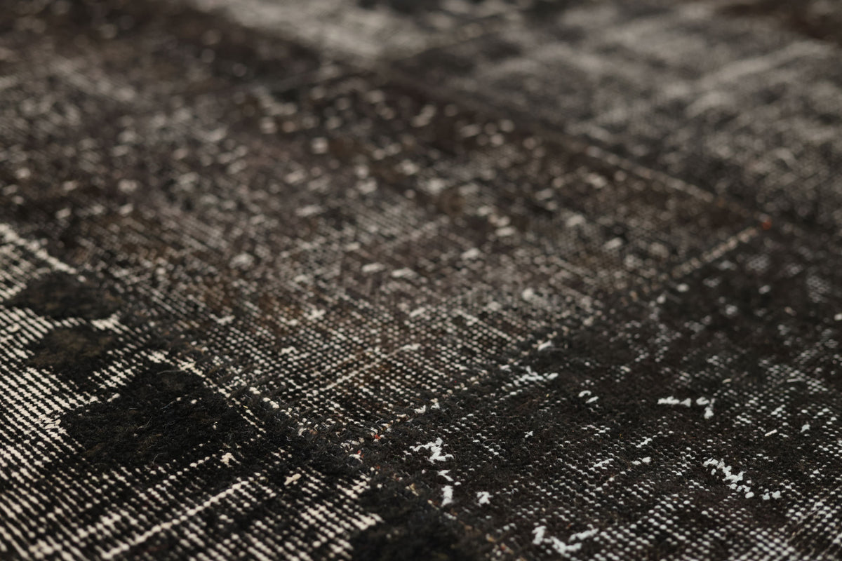 Handmade black patchwork Turkish rug with a distressed, low-pile wool and cotton texture and vintage bohemian patterns.