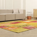 6x9 ft vintage Turkish patchwork area rug in vibrant yellow and red with floral patterns on a hardwood floor.