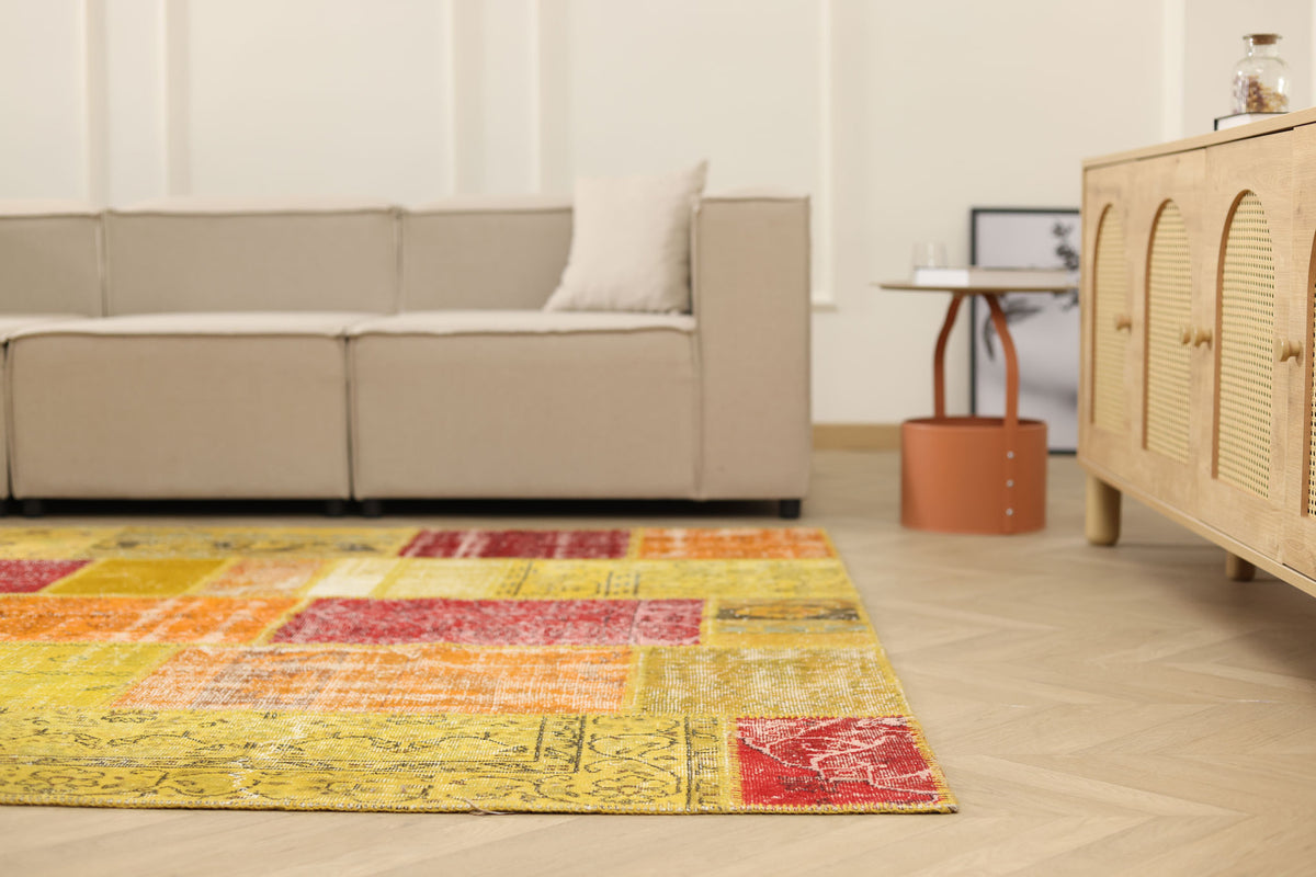 6x9 ft vintage Turkish patchwork rug in vibrant yellow and red with floral patterns, made from wool and cotton.