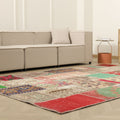 6x10 ft vintage Turkish patchwork area rug with vibrant floral patterns, hand-stitched wool and cotton in a bohemian living room.