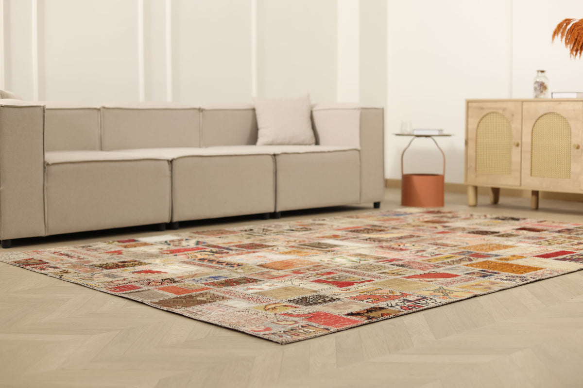 6x9 ft vintage Turkish patchwork area rug with vibrant geometric patterns in wool and cotton on a herringbone floor.