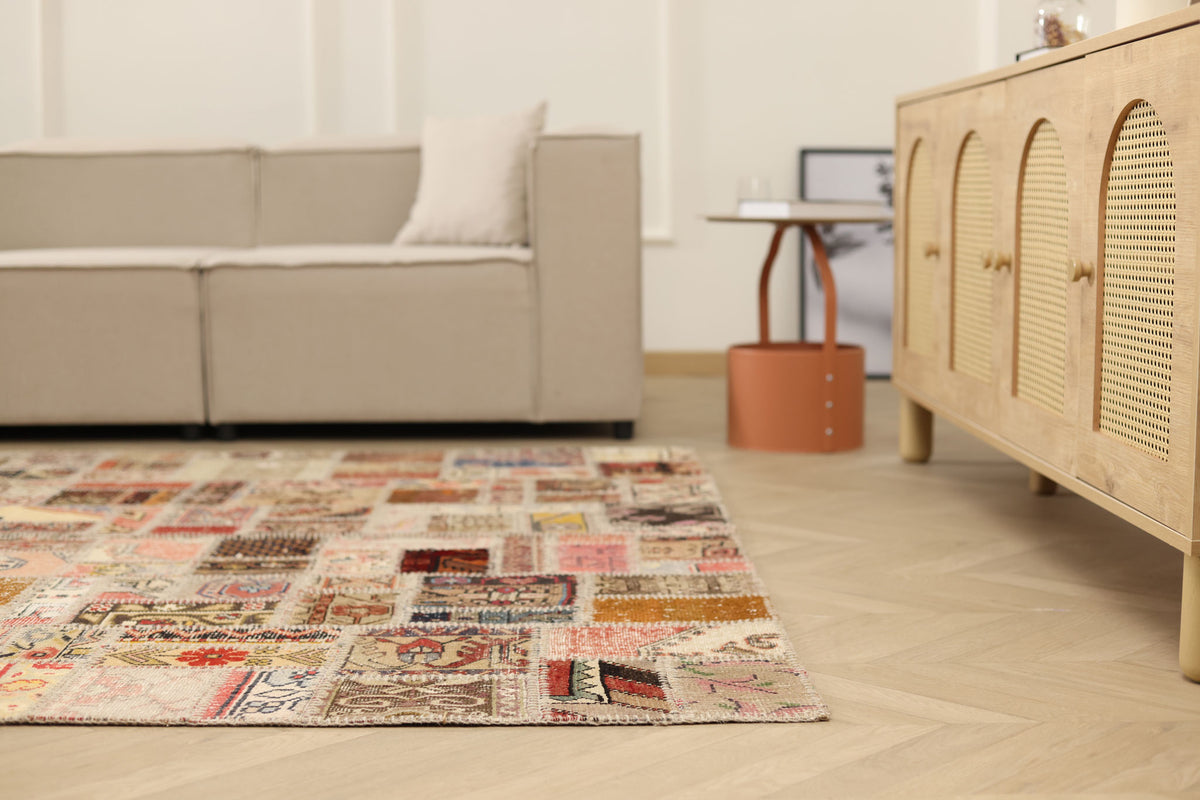6x9 ft vintage Turkish patchwork area rug with vibrant geometric patterns in wool and cotton in a modern living room.