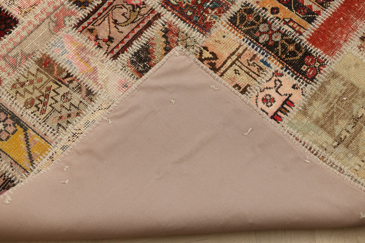 Handmade 6x9 ft vintage Turkish patchwork rug with colorful geometric patterns and a durable cotton backing.