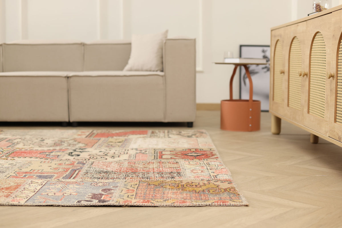 6x9 ft vintage Turkish patchwork area rug with vibrant geometric patterns in wool and cotton on a hardwood floor.