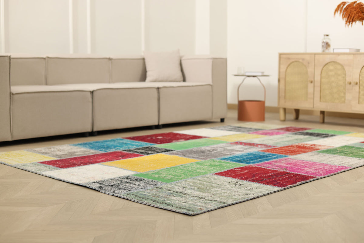 6x9 ft vintage Turkish patchwork area rug with vibrant, distressed wool and cotton squares in a bohemian living room.