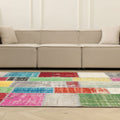 6x9 ft vintage Turkish patchwork area rug with vibrant, distressed wool and cotton squares in a bohemian living room.