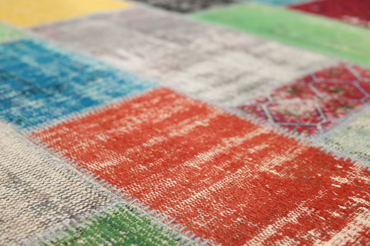 Handmade 6x9 ft vintage Turkish patchwork rug featuring vibrant, distressed wool and cotton squares in a bohemian style.