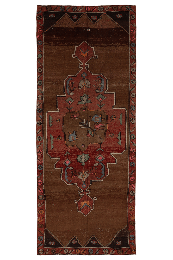 A traditional Persian-style runner rug with a central medallion design in shades of brown, red, and black, shown flat against a white background.