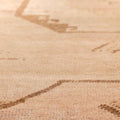 Close-up of a vintage hand-woven Turkish runner rug in beige and red with geometric patterns and wool-cotton texture.