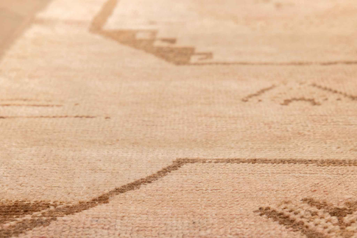 Close-up of a vintage hand-woven Turkish runner rug in beige and red with geometric patterns and wool-cotton texture.