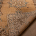 Handmade vintage Isparta runner rug in yellow and beige wool with traditional floral patterns and a folded corner.