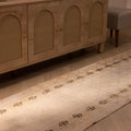 Vintage hand-woven 10ft beige Turkish runner rug with geometric patterns in wool and cotton on a wooden floor.