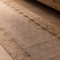 Hand-woven 10ft beige vintage Isparta runner rug with geometric patterns in wool and cotton on a wooden floor.