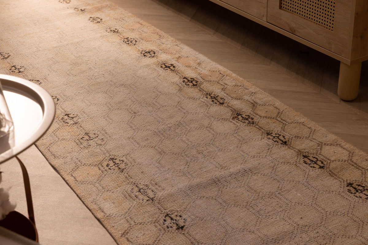 Hand-woven 10ft beige vintage Isparta runner rug with geometric patterns in wool and cotton on a wooden floor.