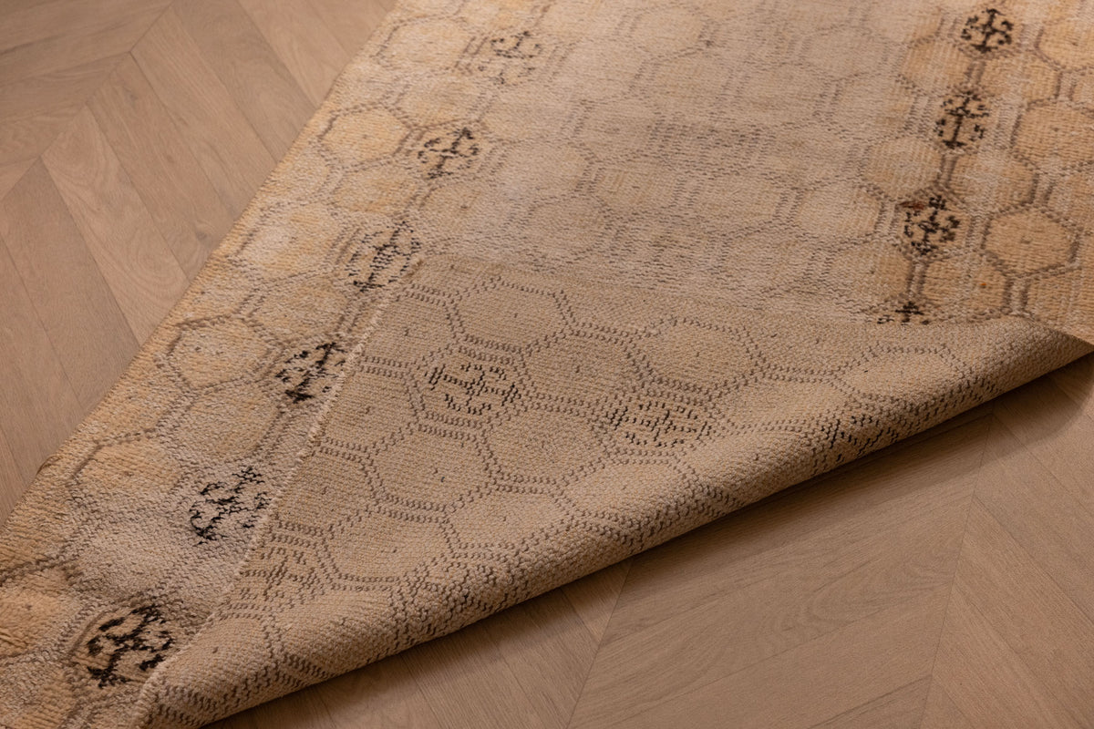 Hand-woven vintage Isparta runner rug in beige with geometric patterns, crafted from wool and cotton on a wooden floor.