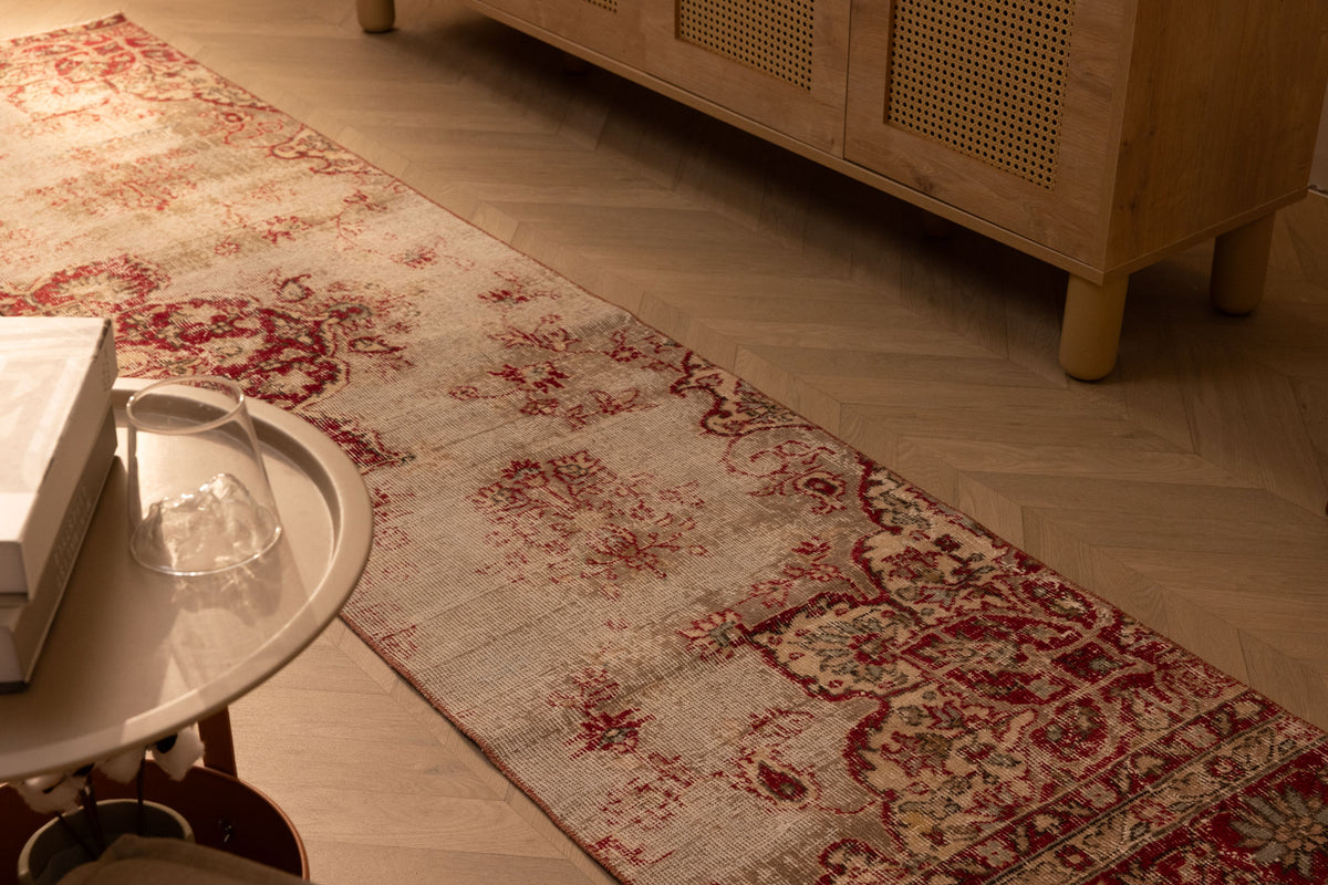Vintage red and white floral Isparta runner rug, hand-woven wool and cotton, displayed on a herringbone wood floor.
