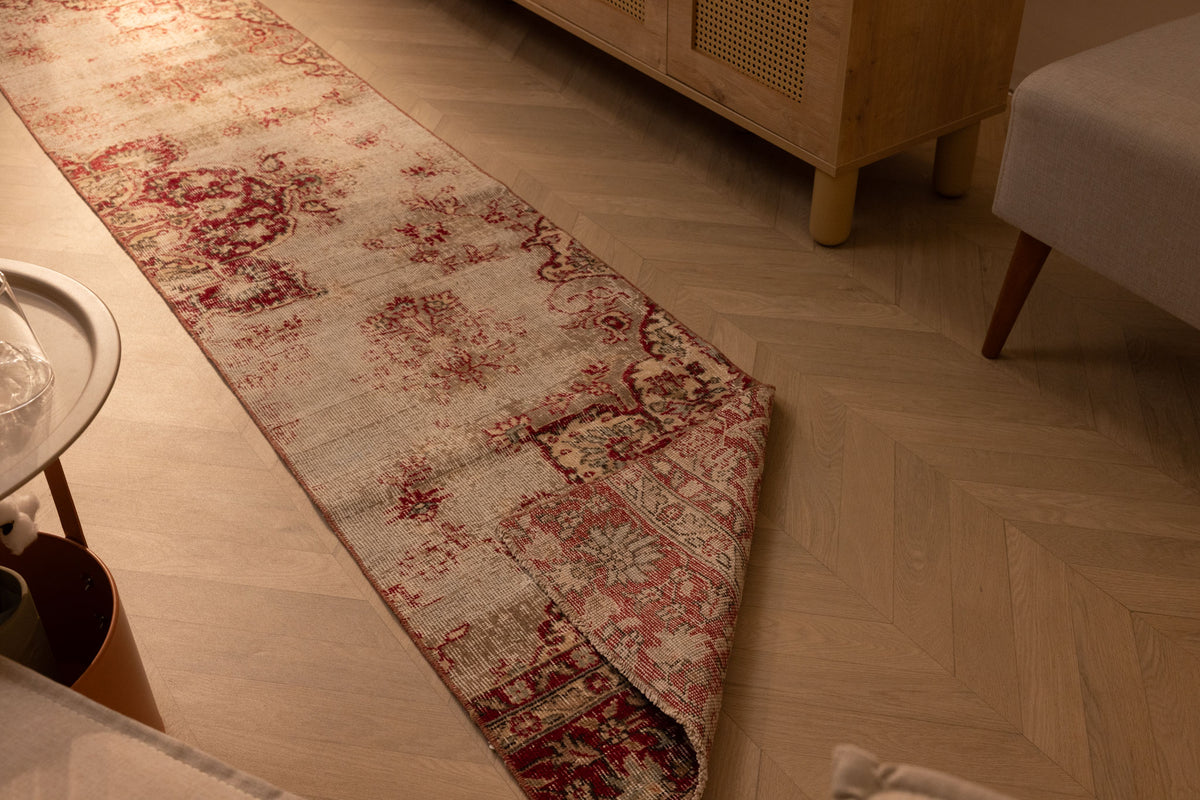 Vintage handmade Isparta Turkish runner rug in red and white floral wool and cotton on a herringbone wood floor.