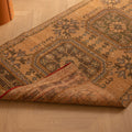 Hand-woven vintage Konya runner rug in beige and brown wool with geometric patterns on a wooden floor.