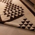 Handmade wool and cotton Persian-style runner rug in white and brown with geometric patterns on a wooden floor.