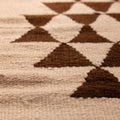 Handmade white and brown wool-cotton flatweave runner rug featuring a geometric triangle pattern in farmhouse style.