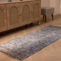 Vintage navy overdyed Turkish runner rug in wool and cotton with a bohemian floral pattern on a wooden floor.