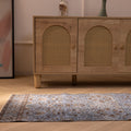 Vintage navy overdyed Turkish runner rug in wool and cotton with bohemian floral patterns on a wooden floor.