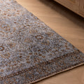 Vintage navy overdyed Turkish runner rug with floral patterns on a wooden floor.