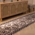 Handmade 3x11 ft gray and brown wool-cotton Persian kilim runner with geometric patterns on a wooden floor.