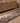 Handmade 3x11 ft gray and brown wool-cotton Persian kilim runner with geometric patterns on a wooden floor.