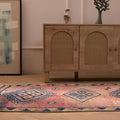 Handmade 3.5x9.9 ft wool and cotton runner rug featuring pink and navy geometric patterns in a bohemian style.